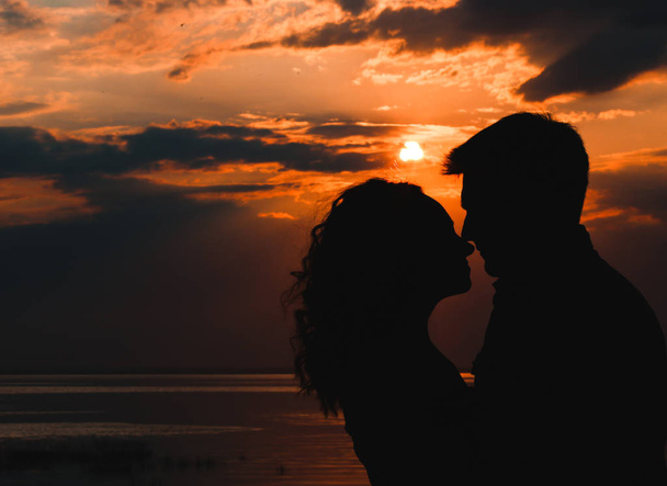 silhouetted couple sea sunset sun  - Photo, image