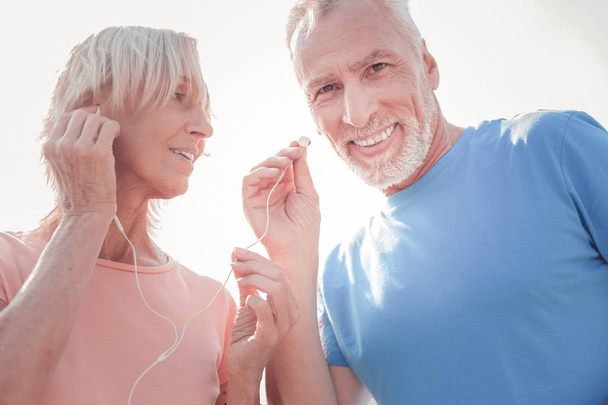 Joyful senior couple smiling and listening to music. - Foto, Imagem
