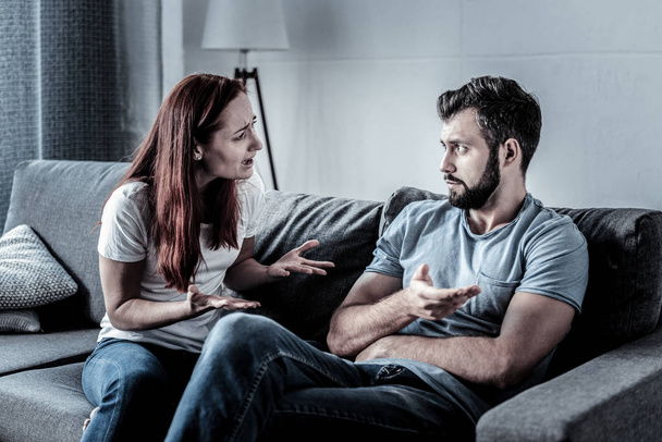 Depressed angry woman gesticulating and talking to her husband. - Photo, image