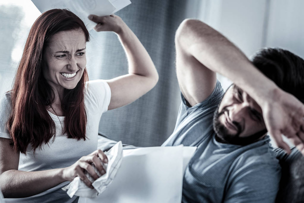 Angry redhead woman quarreling with husband and biting him. - Zdjęcie, obraz