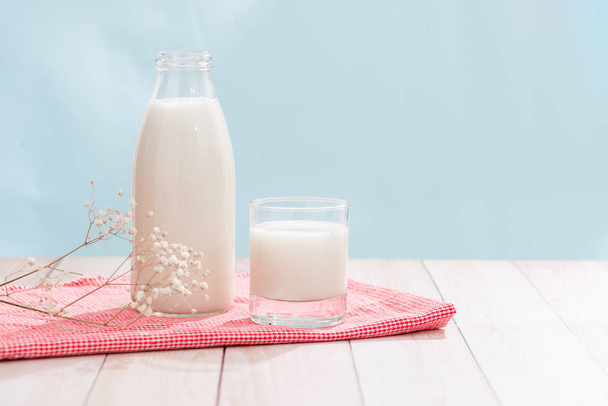 Dairy products. Bottle with milk and glass of milk on wooden table - Foto, imagen