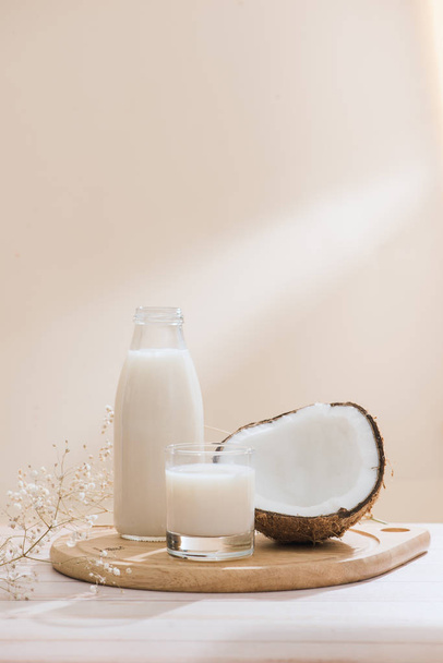 Kokosové mléko v láhvi a sklo na stůl s kopií prostor - Fotografie, Obrázek