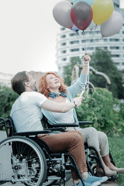 Радостные инвалиды смотрят на свои воздушные шары
 - Фото, изображение