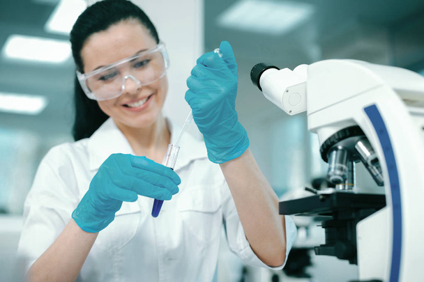 Competent female scientist wearing protective glasses - Foto, Imagem