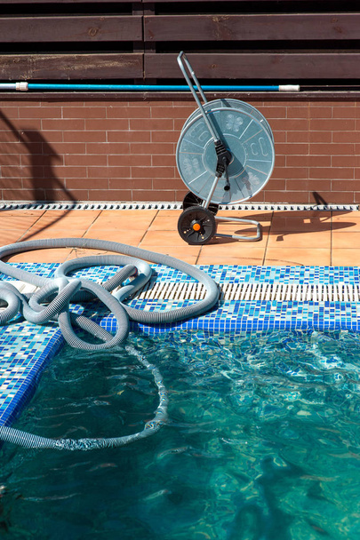 Zwembad schoonmaken proces, machine met buis - Foto, afbeelding