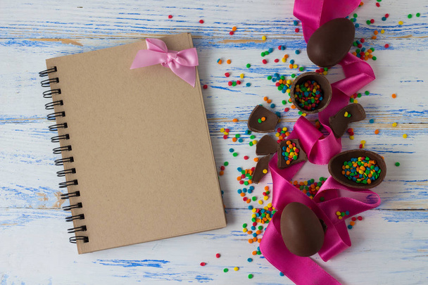 Ovos de chocolate de Páscoa, fita rosa, bloco de notas e Páscoa Multicolore
 - Foto, Imagem