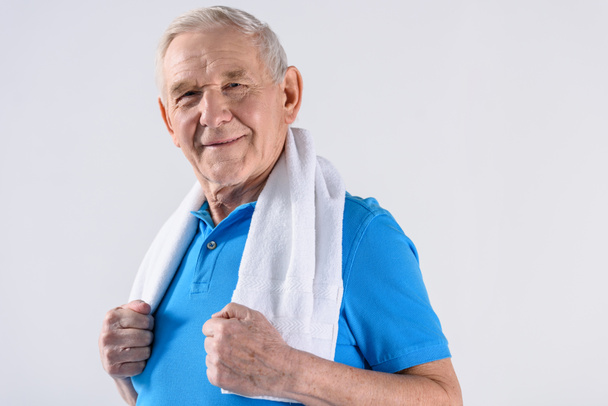 portrait of smiling senior man with towel looking at camera isolated on grey - Foto, Bild