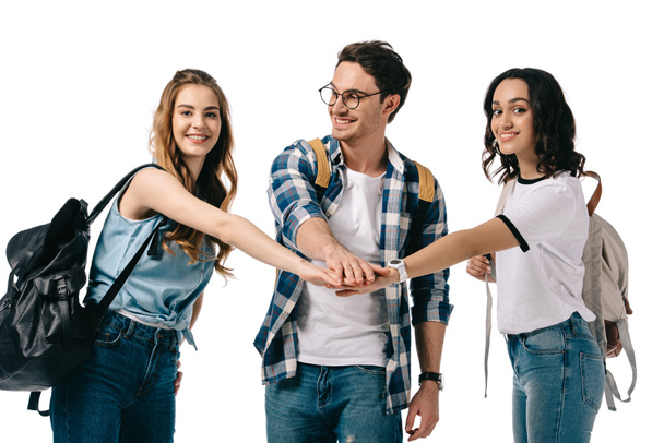 happy multicultural students putting hands together isolated on white - Foto, Bild