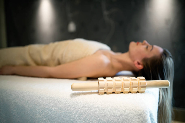 Beautiful woman relaxing on massage bed at cosmetics saloon - Zdjęcie, obraz