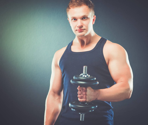 Handsome muscular man working out with dumbbells - Fotoğraf, Görsel