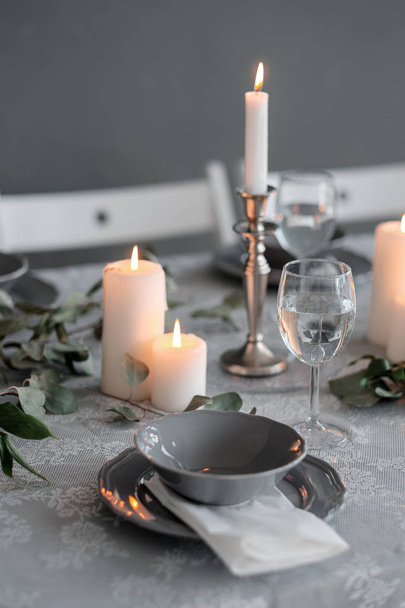 結婚式やお祝いのテーブル設定。皿、ワイングラス、キャンドル、カトラリー - 写真・画像