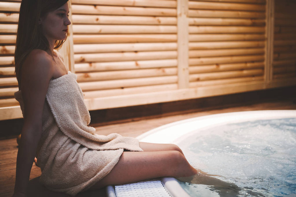 Woman enjoying jacuzzi in spa after sauna - Zdjęcie, obraz