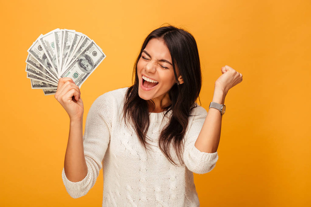 Portrait of a cheerful young woman holding money - Foto, Imagem