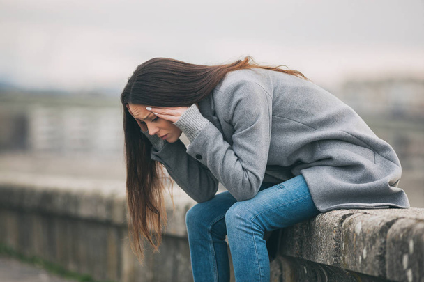 Joven mujer solitaria y deprimida está sentada en el dolor
.  - Foto, Imagen