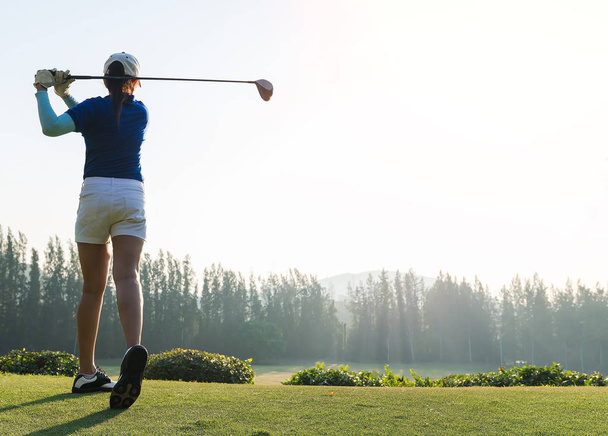 女性ゴルファーが美しい背景の風景にボールを打ちます。ボールに集中. - 写真・画像