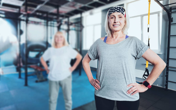 Smiling woman standing with hands on hips at gym - Fotoğraf, Görsel