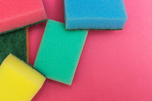 Multicolored sponges on a pink background. - Foto, afbeelding