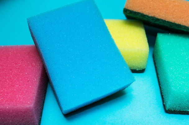 Multicolored sponges on a blue background. - Fotoğraf, Görsel