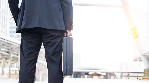 Businessman holding a business briefcase.businessman holding briefcase and going to work time - Φωτογραφία, εικόνα