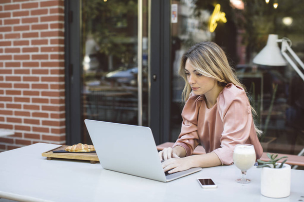 A Woman Typing on Laptop at Coffee Shop - Фото, изображение