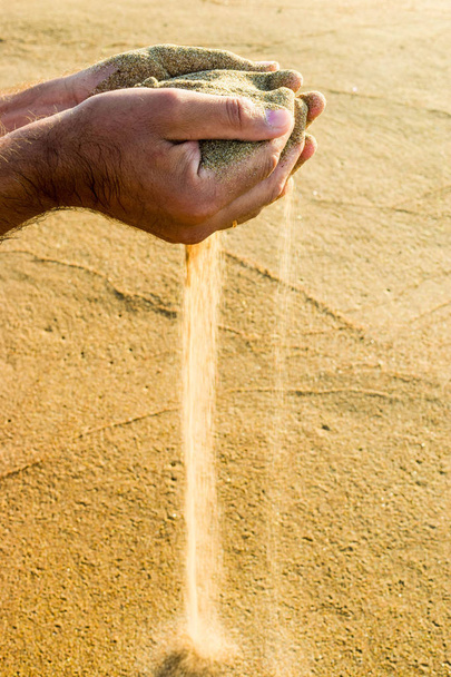 Sand through fingers. - Фото, изображение