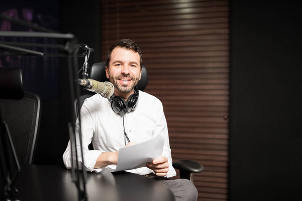 Retrato del joven presentador de radio masculino en la estación de radio con auriculares y micrófono
 - Foto, imagen