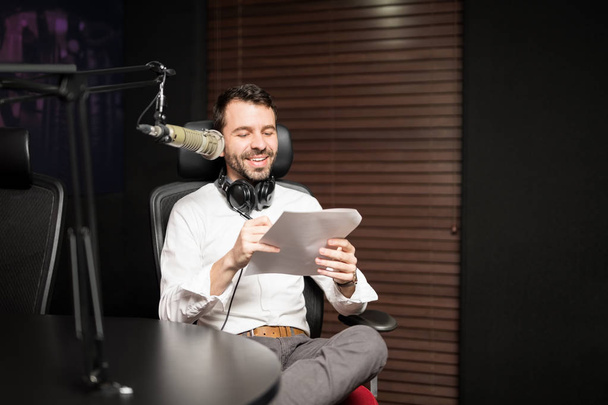 Retrato del joven presentador de radio masculino en la estación de radio con auriculares y micrófono
 - Foto, imagen