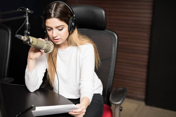 Portrét mladé ženské rozhlasové stanici rádio se sluchátky a mikrofonem - Fotografie, Obrázek