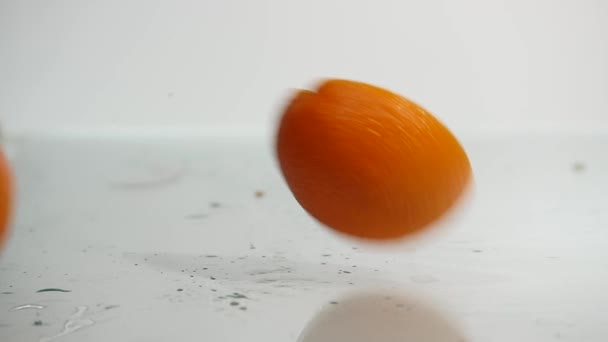Two halves of orange falling on a white background. Fresh orange on white background close up - Filmati, video