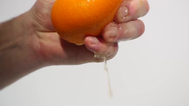 Чоловіча рука стискає свіжий апельсиновий сік. Рука стискає апельсин
 - Кадри, відео