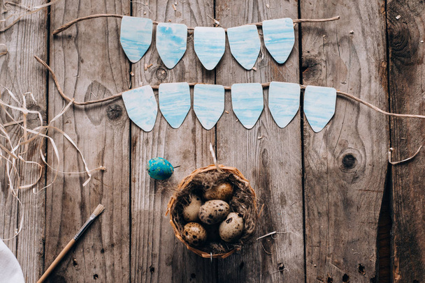 Top näkymä viiriäisen pesä munia, sininen muna, olki ja harja puulaudat tausta
 - Valokuva, kuva