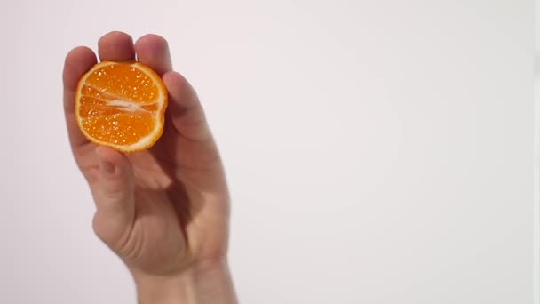 Male Hand Squeezing Fresh Orange Juice.Hand squeezing an orange - Felvétel, videó