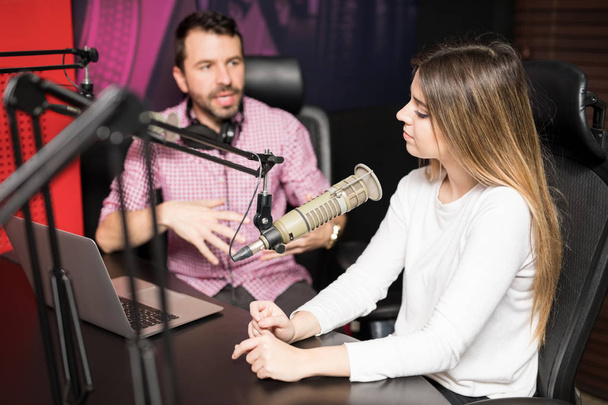 Чоловіча радіоведуча проводить інтерв'ю з відомою жінкою на радіостанції
 - Фото, зображення