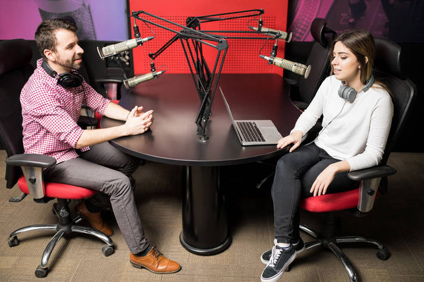 Молодой человек и женщина ведущие на радиостанции в прямом эфире радио-шоу
 - Фото, изображение