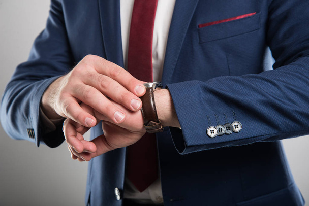 Close-up of business man wearing suit checking wrist watch - Foto, Imagen