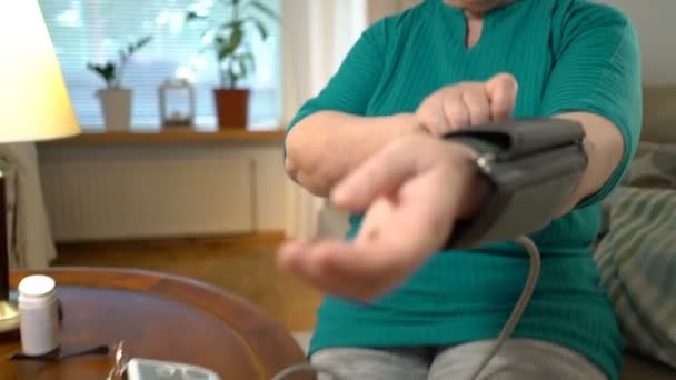 An elderly woman measures blood pressure at home. - Filmagem, Vídeo