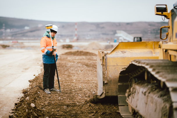 Geodesy details - construction site workers building highway and roads. Surveying engineer details - Foto, Bild