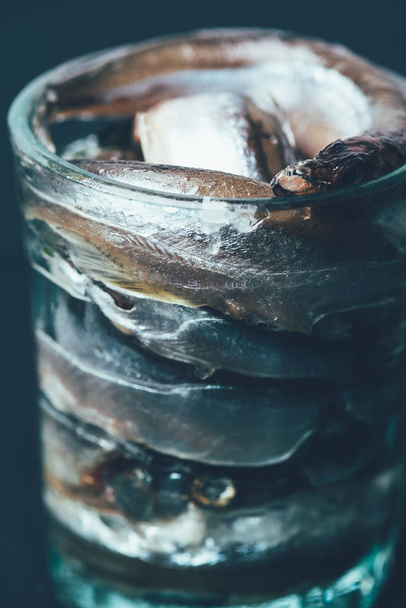 Close up of pile of salted fish in glass isolated on black - Fotografie, Obrázek