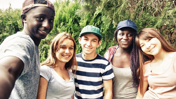 Multi etnische tieners glimlachend buiten maken selfie. - Foto, afbeelding