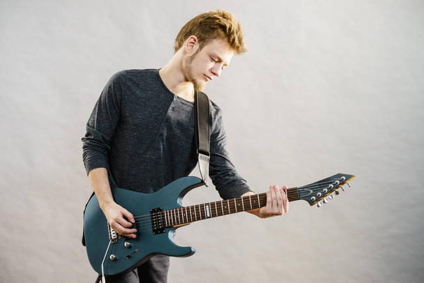 Young man playing electric guitar - Foto, Bild
