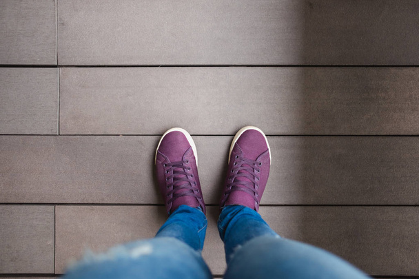 vista dall'alto piede donne con jean e supporto per scarpe su pavimento in legno bac
 - Foto, immagini