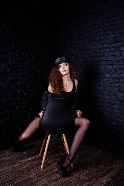 Brunette curly haired long legs girl in black leather jacket wit - 写真・画像