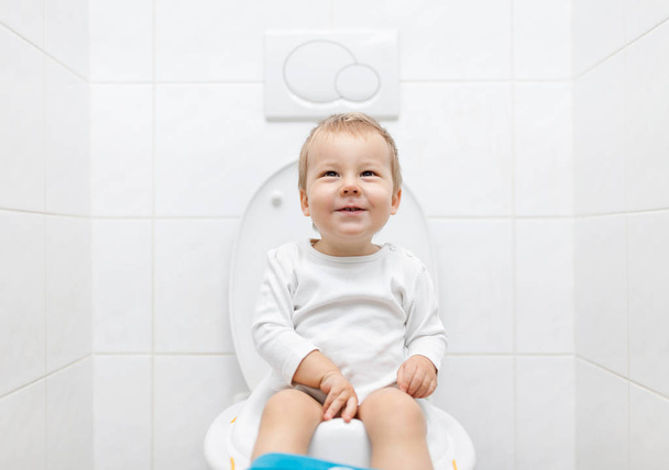Criança adorável sentada no banheiro
 - Foto, Imagem