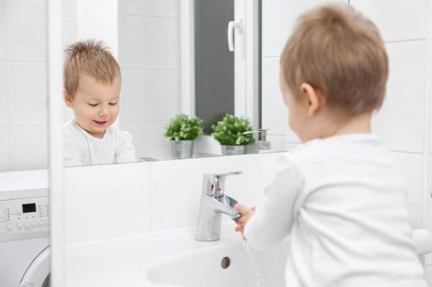 Cute toddler learning how to wash his face - 写真・画像