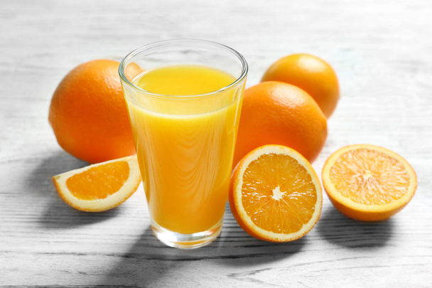 Glass of orange juice and fresh fruits on table - Fotoğraf, Görsel