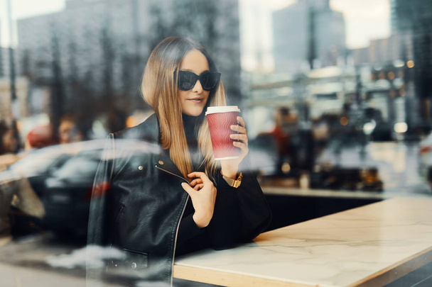 Young girl sit in coffee place in front of the window look at he - Фото, зображення