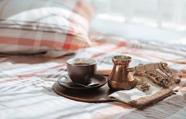 Tray with tasty coffee into a cup on the bed. - Fotó, kép
