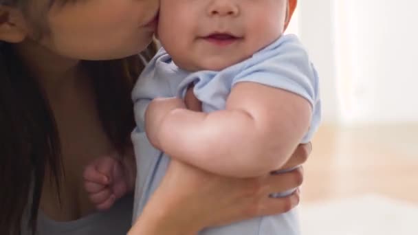 šťastná mladá matka líbání doma malé miminko - Záběry, video