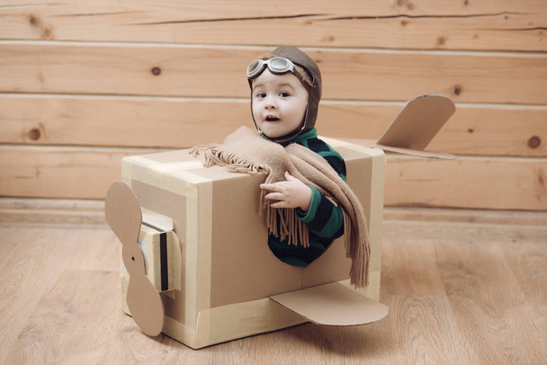 Eight-year boy playing with a cardboard airplane - Zdjęcie, obraz