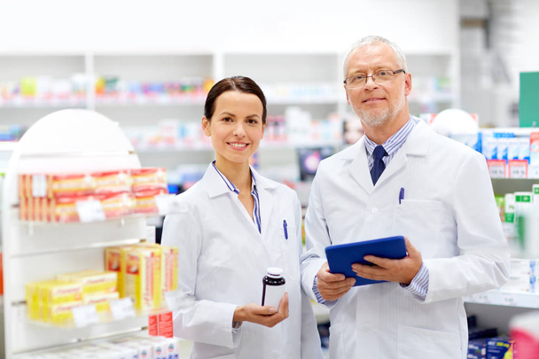 apothecaries with tablet pc and drug at pharmacy - Photo, Image